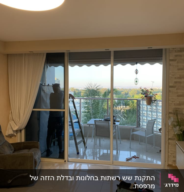 אדם עובד על דלת אלומיניום במרפסת